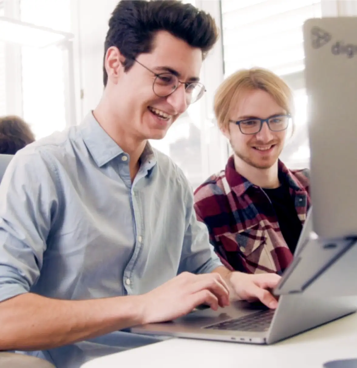 Mitarbeiter der Digio arbeiten gemeinsam am Computer.